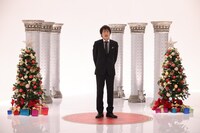 「聖夜の細身センスメガネSP」より、クリスマスツリーの間に立つ千原ジュニア