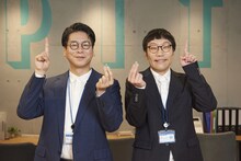 インタビューで生まれた「上手にできました」の「上手」ポーズを見せる男性ブランコ