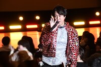 マイクを持つ手を振りながら歌唱するヤジマリー。