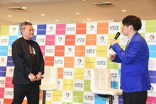 プロデューサーとジャンケンをして複数案から番組ロゴを決めるグランジ遠山（右）