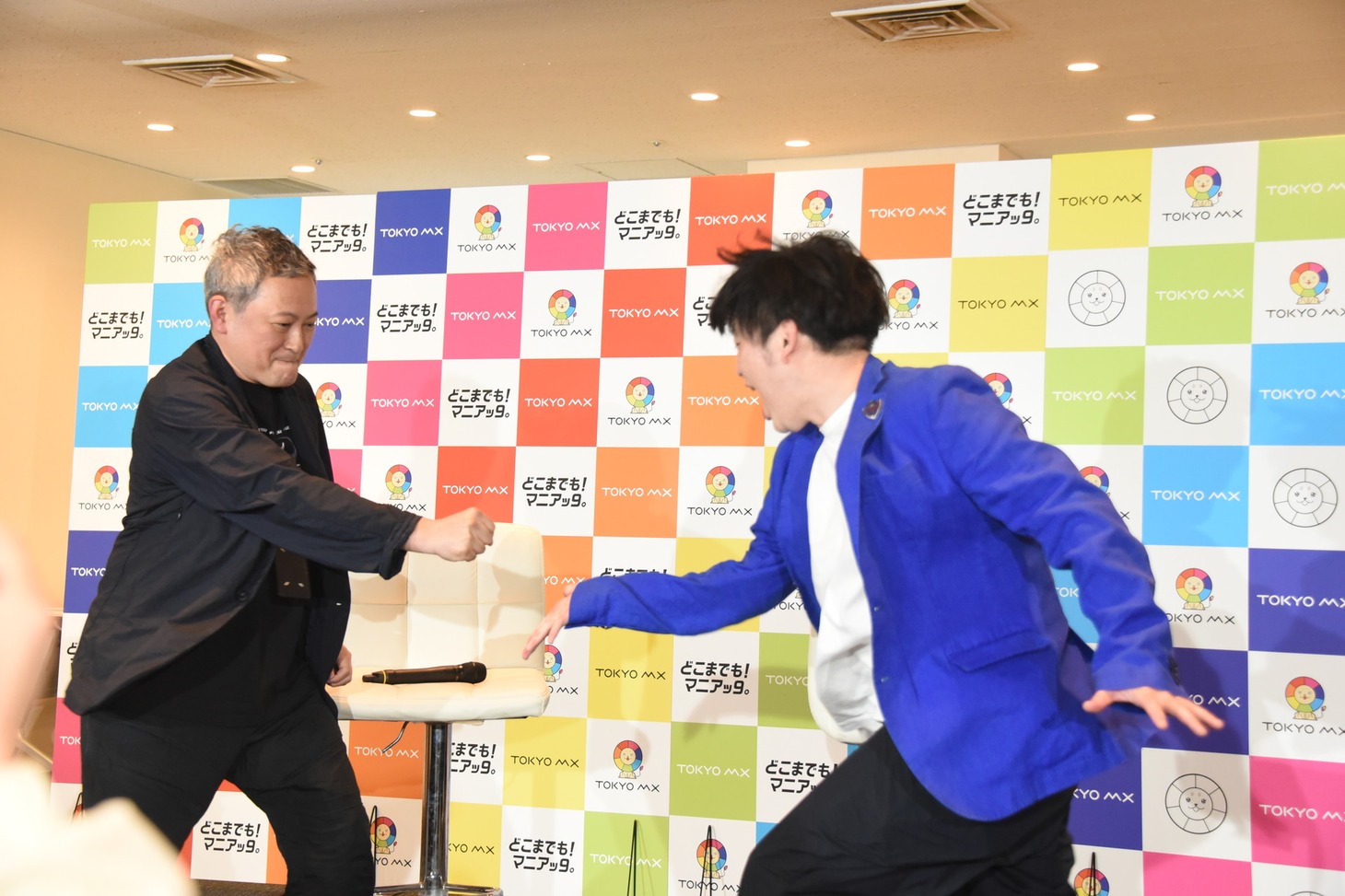 プロデューサーとジャンケンをして複数案から番組ロゴを決めるグランジ遠山（右）