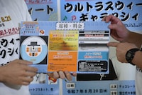 券種が書かれたボードを見せるチョコレートプラネット。「緊急で作った」ため見づらい