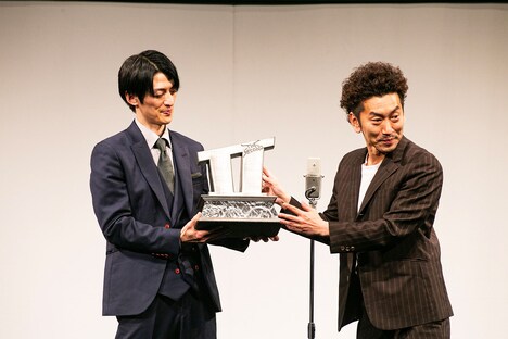 観客にトロフィーを見せるツートライブ