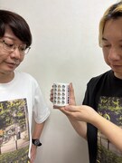 「祝！結成20周年 記念湯呑み」を持つ三四郎