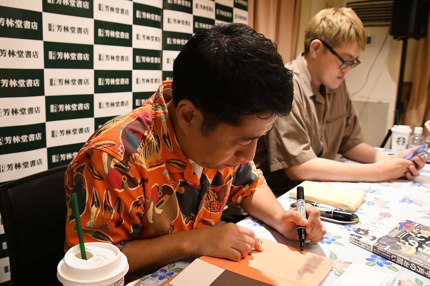 「書籍!!今月のお笑い」にサインを入れる井口