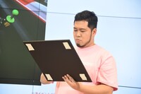 自身の作品のパネルにサインを書く令和ロマン・松井ケムリ