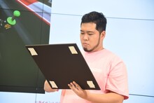 自身の作品のパネルにサインを書く令和ロマン・松井ケムリ