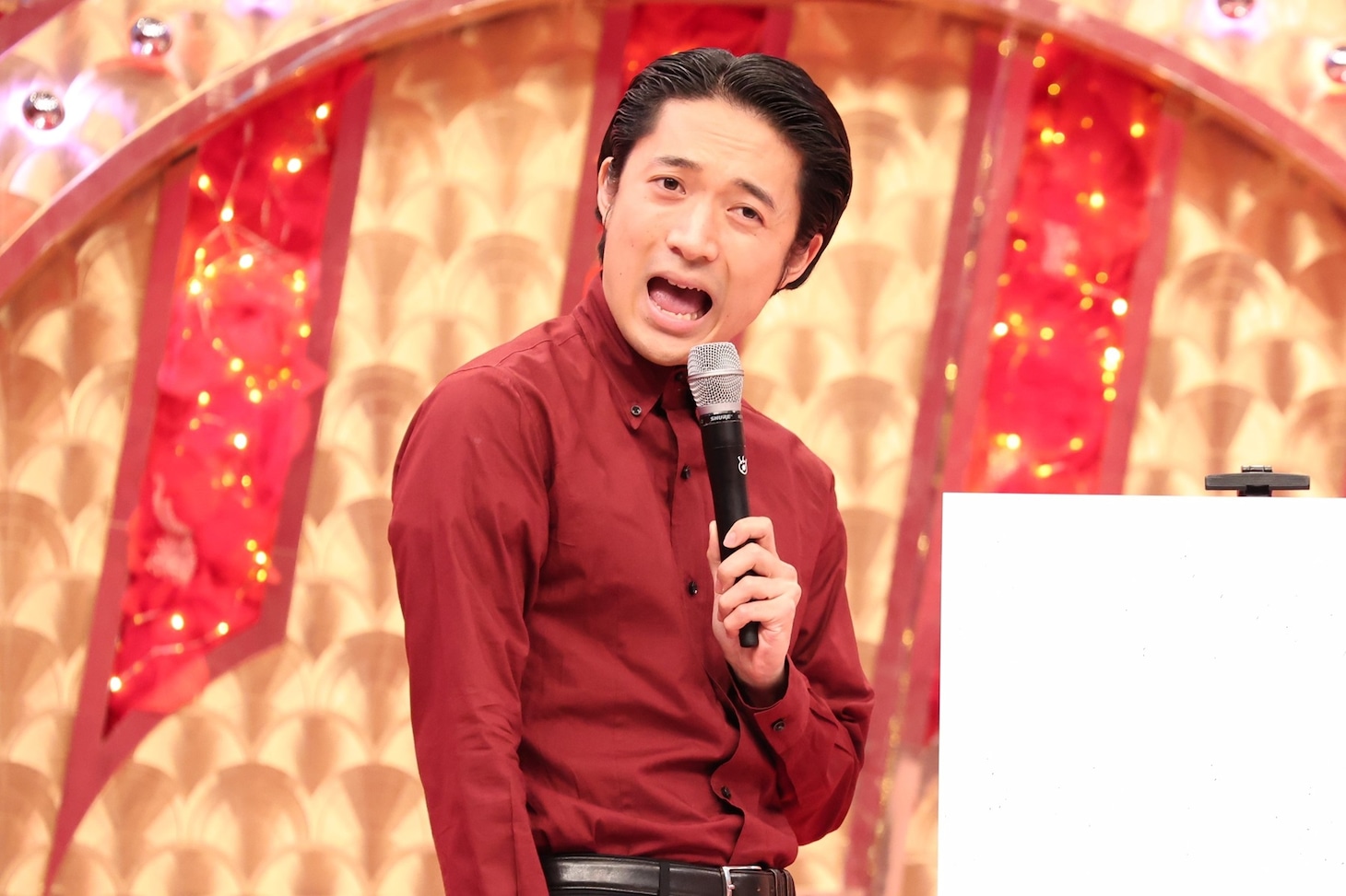 「爆笑レッドカーペット」のセットをバックにネタを披露する友田オレ
