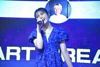 歌う渋谷凪咲。後ろには応援者としてリリーが映し出されている