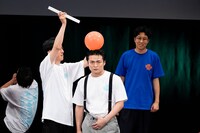 「ノーリアクション風船爆破」に挑む男前な表情のケビンス・山口コンボイと、それとは対称的なドーナツ（後方）