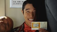 トム・ブラウンが出演するCM「MEGA BIG １２億の案内人億山・電車でのモヤモヤ」編のワンシーン