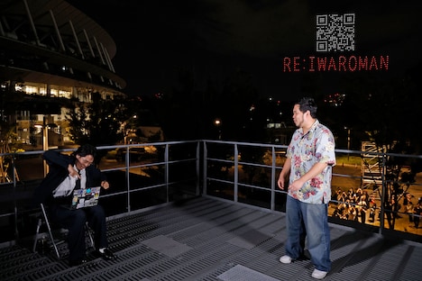 ノートパソコンでドローンを操っているかのように振る舞うくるま（左）