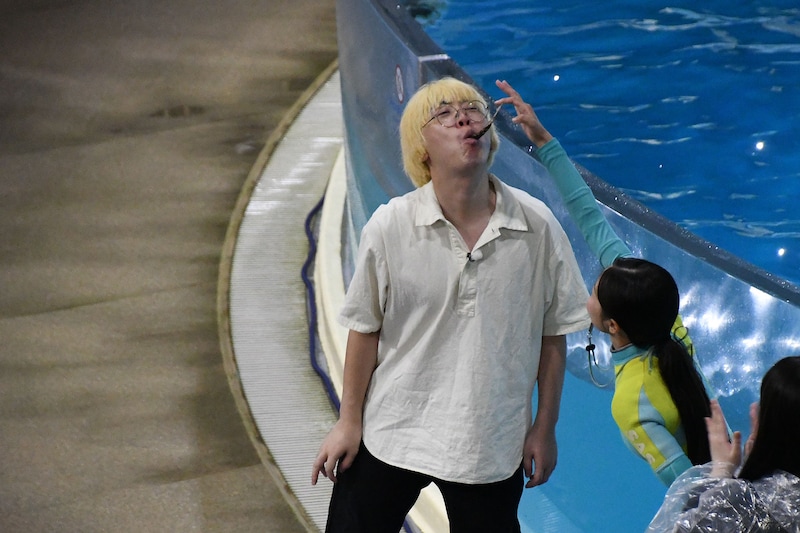 トレーナーに魚をもらうニンゲンのガク