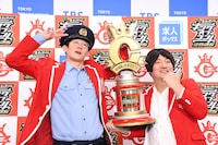 フォトセッション中のロングコートダディ。トロフィーが重く、兎（右）の腕に限界が近づく