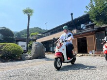 電動バイクにまたがる唐沢寿明