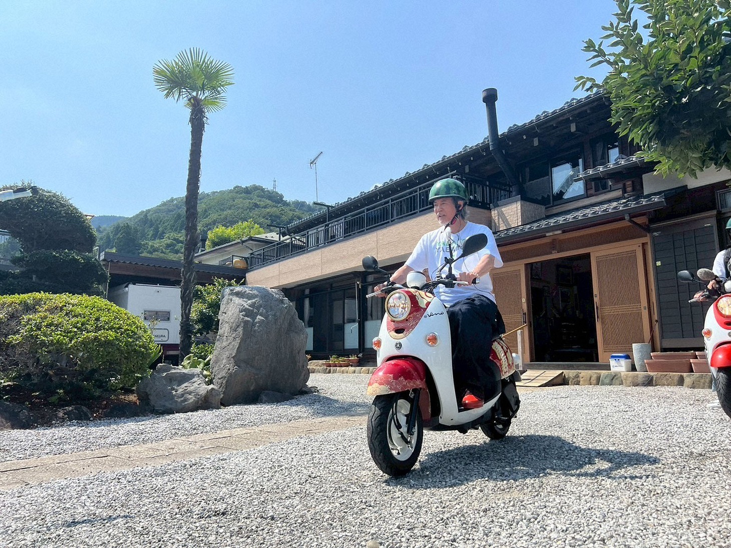 電動バイクにまたがる唐沢寿明