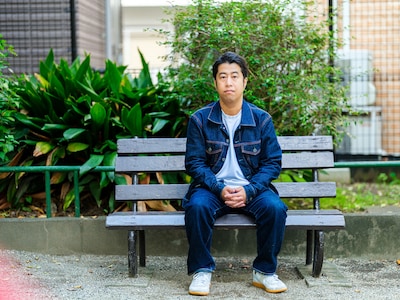 「悪口を悪く言うな！」より、ベンチに腰掛け正面に目線を送る井口の撮り下ろし写真