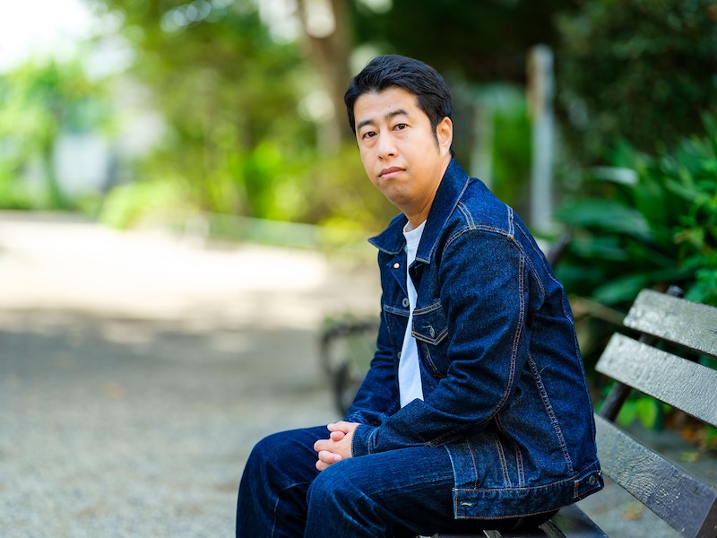 「悪口を悪く言うな！」より、ベンチに腰掛ける井口の横向きの撮り下ろし写真