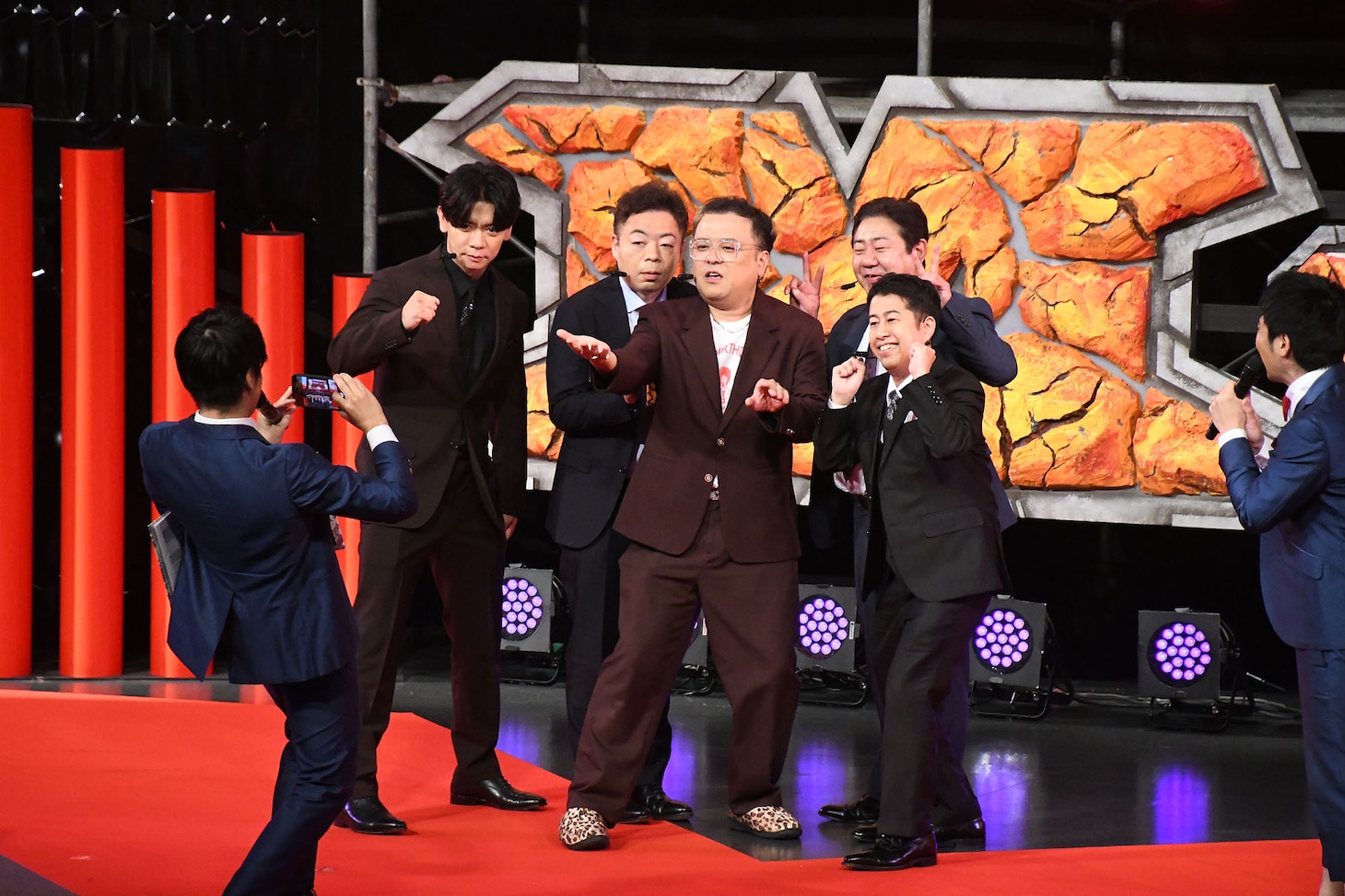 ステージ上でスマイルに写真を撮ってもらう芸人審査員たち