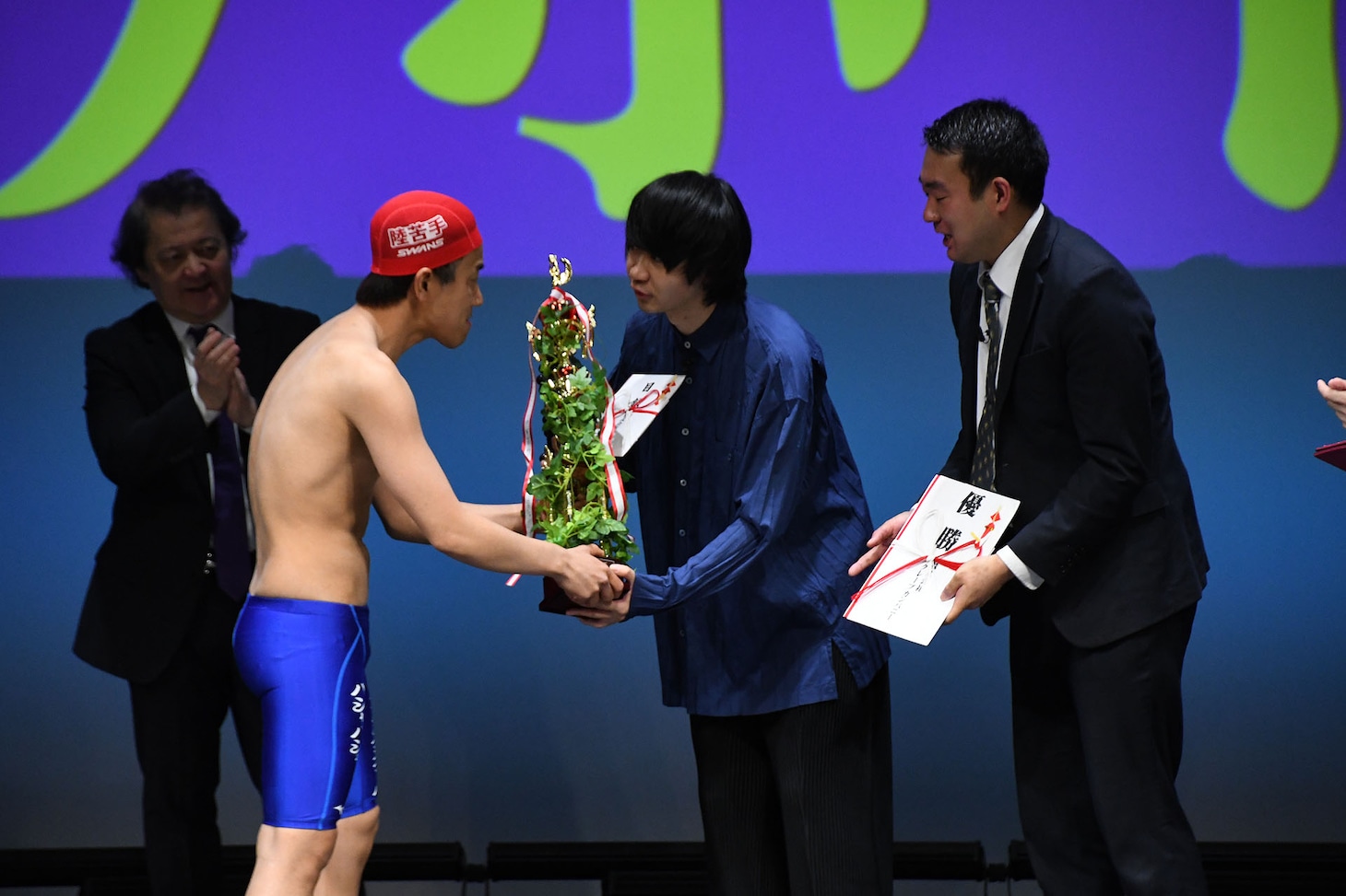同じ出場者だったはずの本多スイミングスクールからトロフィーを受け取るヤッホイ