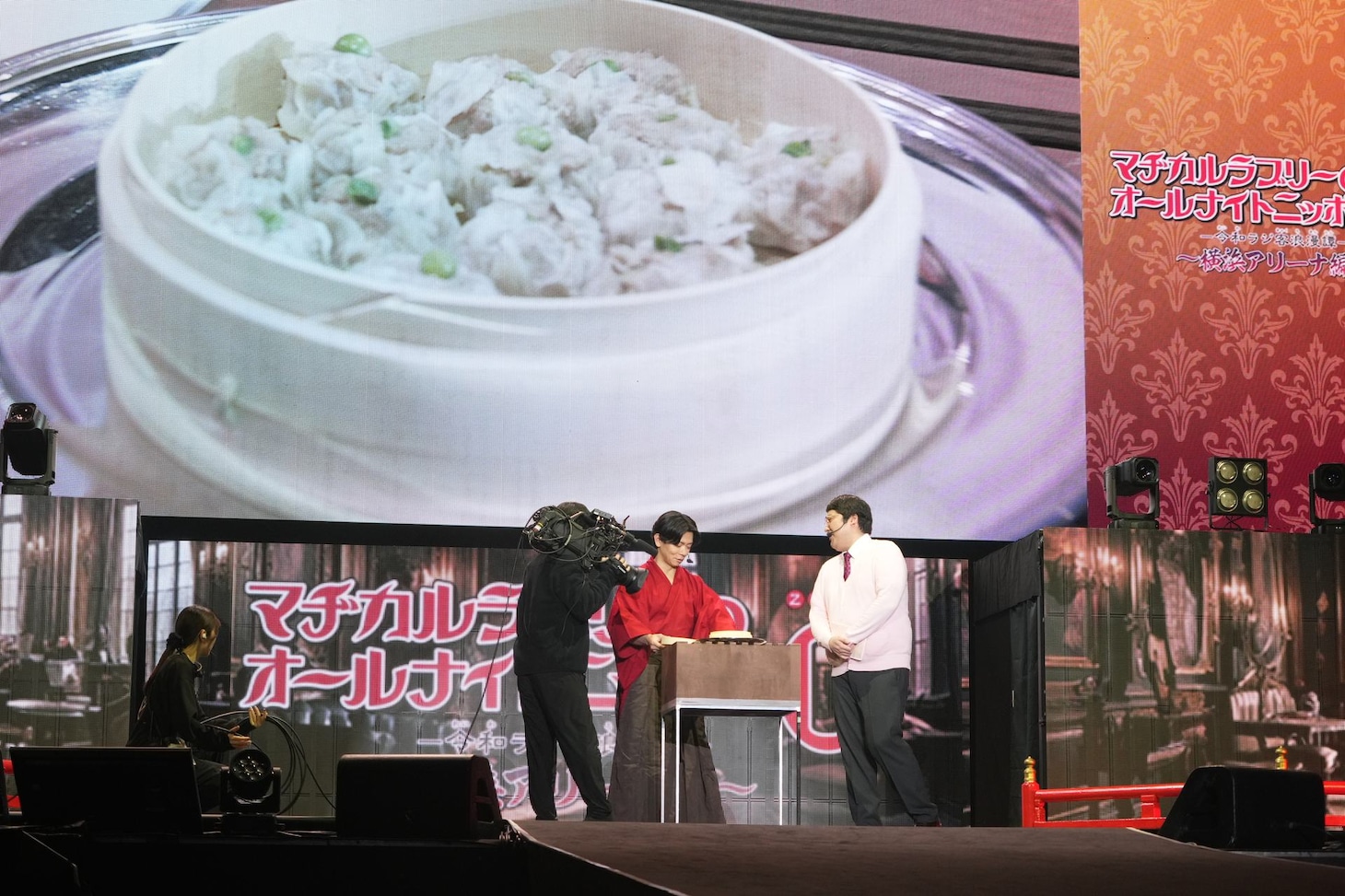 野田の母が手作りした“シウマイ”をステージ上で試食する場面