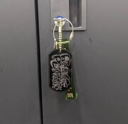 「ヤマゲンデザイン『Prank Permit』BLACKタグ」。一緒に付いているのはシティホテル3号室のグッズのホテルキー