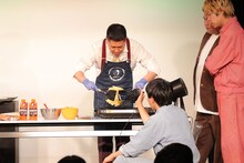 「第一回コナ-1グランプリ」優勝はドンデコルテ、渡辺がお好み焼きを手際よく焼く