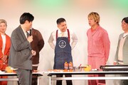 ステージでお好み焼きを作るため、エプロンを着用するドンデコルテ渡辺