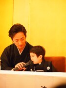 中村七之助（左）に介添えされながらマイクで話す波野哲之。