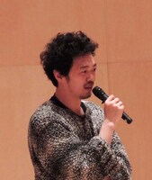 4月4日に行われたプログラム説明会で、丸尾丸一郎が発言する様子。