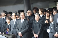 出棺を見送る弔問客。