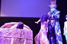 取っ組み合いをする貞子と伽椰子を、デーモン閣下がたしなめる様子。