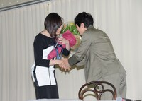 ミッツ・マングローブ（左）に花束を渡す佐々木蔵之介。