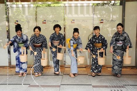 「頭痛肩こり樋口一葉」出演者がシアタークリエの正面玄関で打ち水を行う。