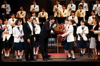 「熱血！ブラバン少女。」カーテンコールより、宮崎香蓮（右）に花束を渡す博多大吉（中央）。