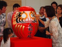 公演成功祈願の大ダルマに目入れする高畑淳子。