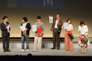 出航式参加者全員にクリアファイルを配る出演者一同。