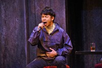 熱唱する足立健（太賀）。