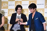 熱弁を振るったのち、中村誠治郎（左）にマイクを返す佐藤アツヒロ（右）。