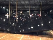 KAAT×地点 共同制作第8弾「山山」稽古の様子。山の斜面にも埋もれて朽ちかけた家にも見える舞台装置に立つ俳優たち。