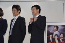 金児憲史のものだというネクタイを示す岩永ジョーイ（中央）。