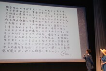 尾田栄一郎からの直筆メッセージを眺める、応援サポーターの山里亮太と平祐奈。