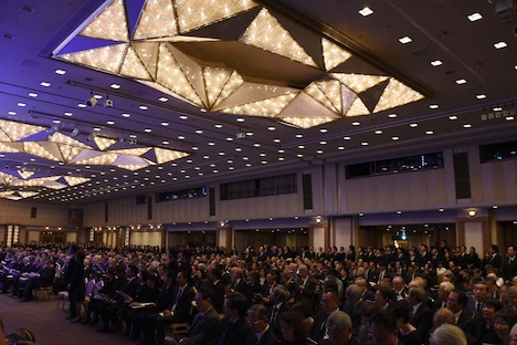 起立して「愛した日々に悔いはない」を歌唱する劇団四季の劇団員たち（後方）。