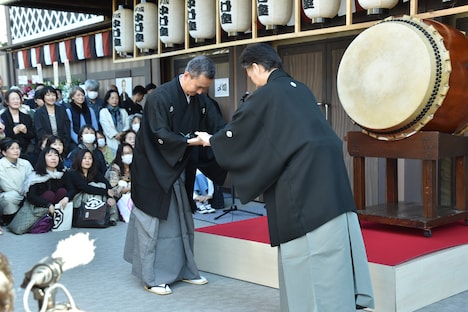 田中傳次郎(左)にばちを手渡す中村七之助(右)。