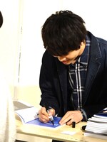「sincere blue」にサインする多和田任益。