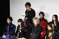 雨宮慶太監督からのメッセージを代読する岩田有弘（奥）と衣装の腕が銃になっている岩田の代わりにマイクを持つ井上正大（手前）。