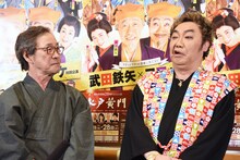 顔は美川憲一、声は武田鉄矢の合体モノマネ“武田憲一”を披露するコロッケ（右）と、それを見つめる武田鉄矢（左）。