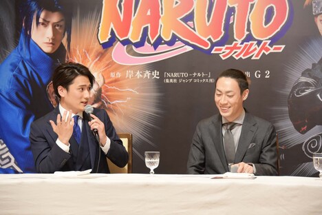 新作歌舞伎「NARUTO-ナルト-」製作発表より、「カラーコンタクトを入れるのが怖くて……」とジェスチャーを交えて語る中村隼人(左)と、隼人の様子に笑う坂東巳之助(右)。