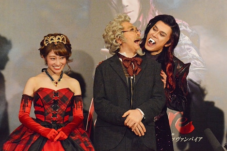 ミュージカル「ダンス オブ ヴァンパイア」初日前会見より。石川禅(中央)の挨拶中に背後から忍び寄り、噛み付くふりをする山口祐一郎(右)。左は山口と石川の仲むつまじさに笑う桜井玲香。