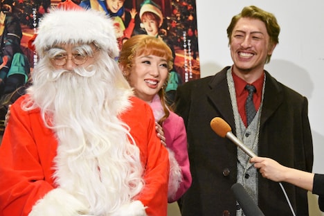 ブラザートムの後ろから顔を出してインタビューに応じる沙央くらま（中央）。